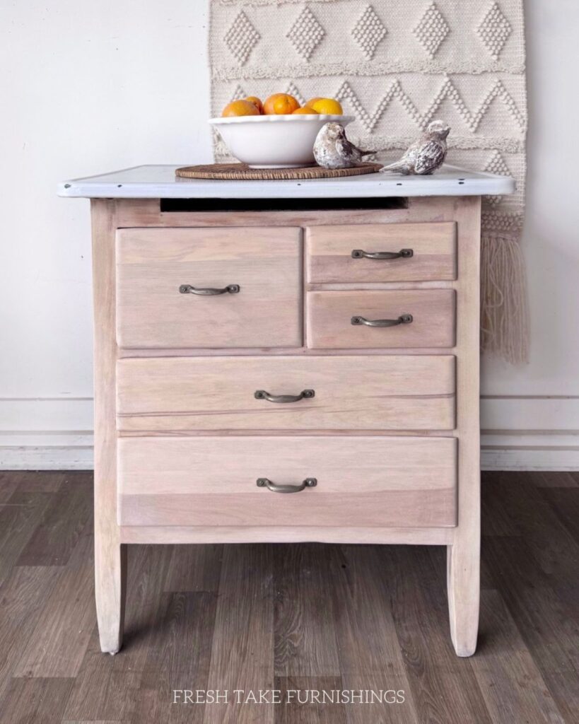 After photo of the wash stand. The wood has been refinished in a natural raw wood finish and the metal enameled top cleaned up.