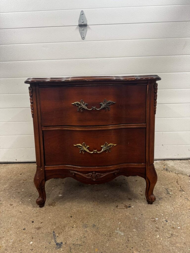 Before photo of French provincial nightstand with a dark brown stain.
