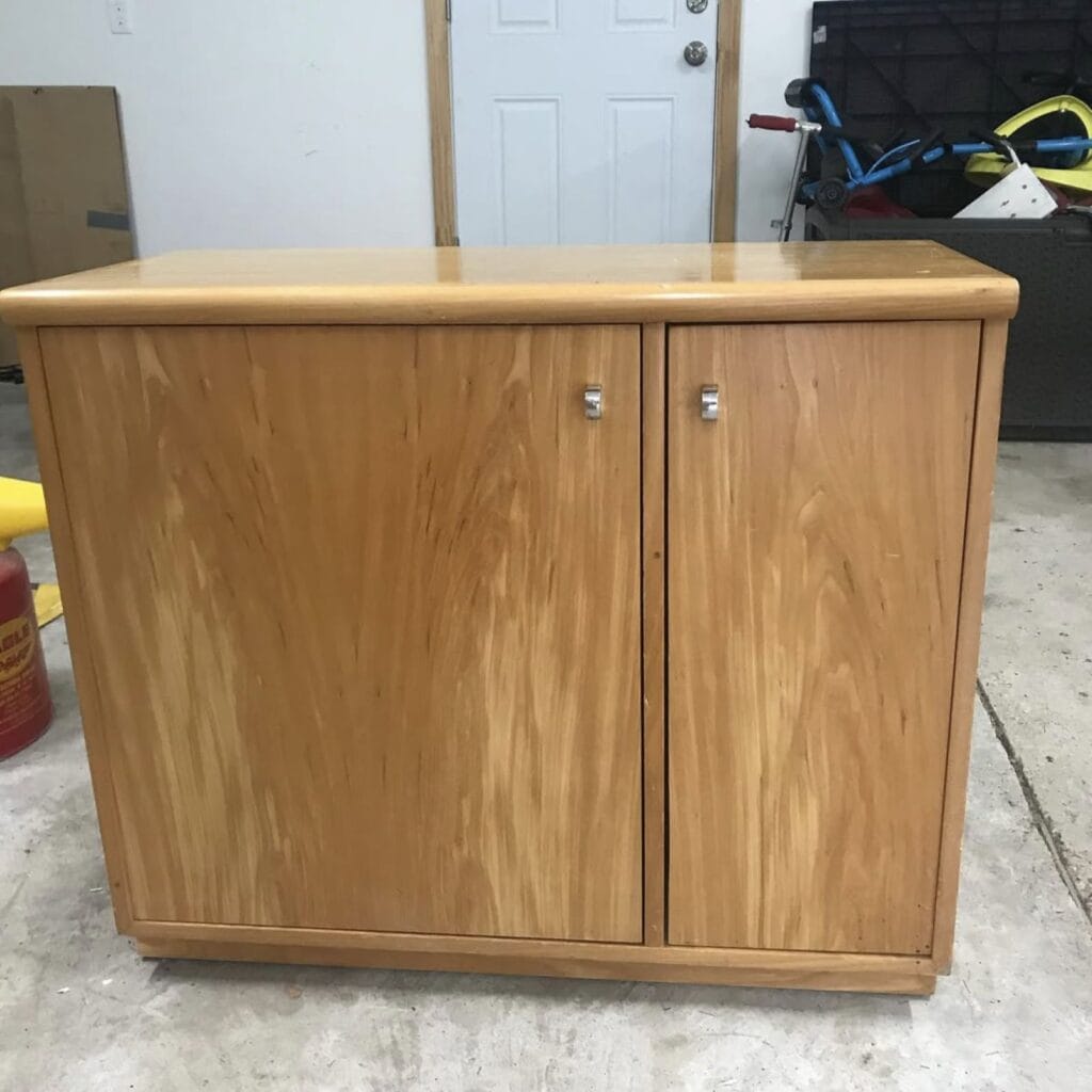 Before photo of a wood cabinet with a light stain.